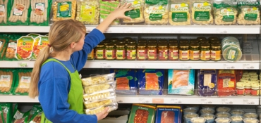 Woman stacking shelves in supermarket